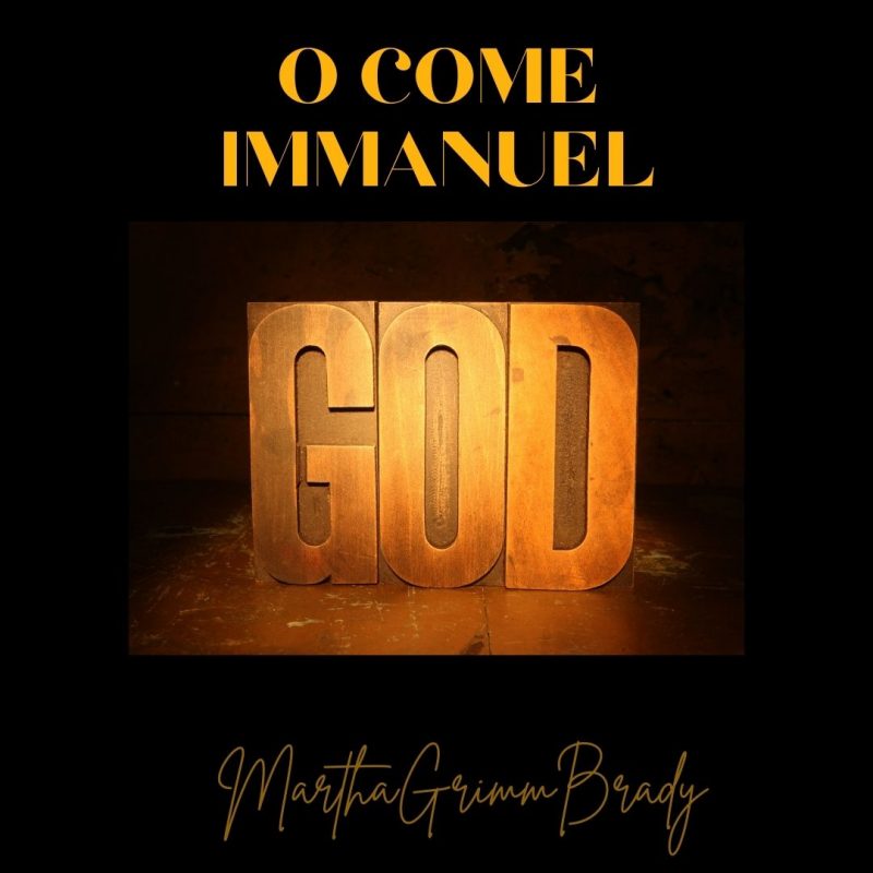 Photo of word God on platform with title O Come Immanuel added above it. Black background.